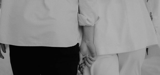 a couple holding hands while standing next to each other